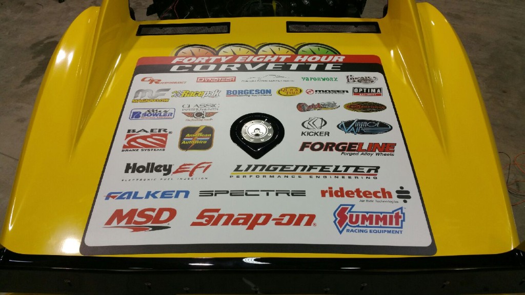 A yellow truck with a lot of different logos on it.