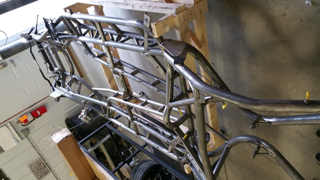 A motorcycle frame is being built in a garage.