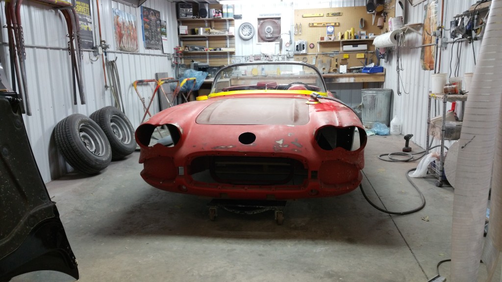 deep red corvette in garage being repaired