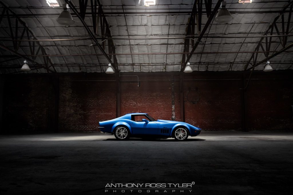 side view blue corvette parked in warehouse