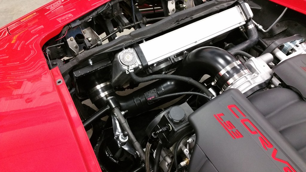 The engine compartment of a red sports car.