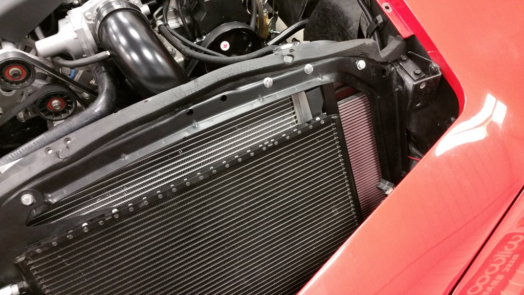 A red car with a radiator in the engine bay.