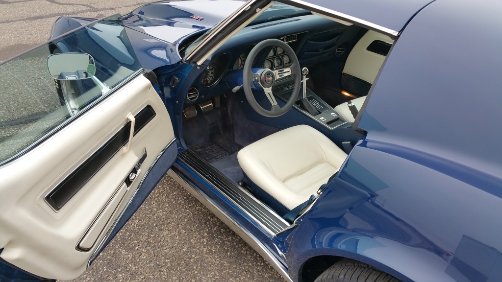 The interior of a blue sports car with the door open.