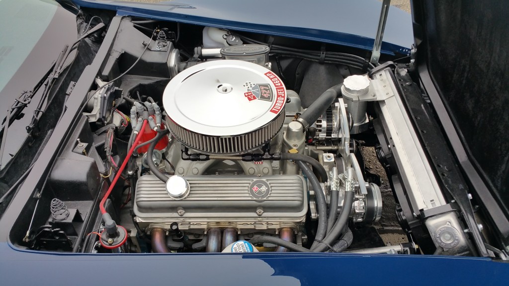 The engine compartment of a blue sports car.