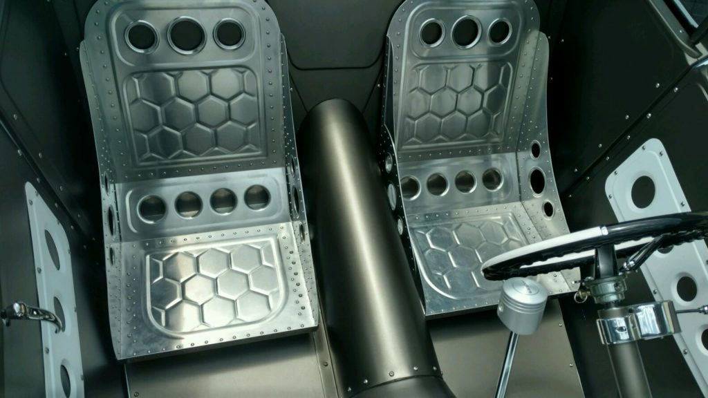 The interior of a car with a steering wheel and pedals.