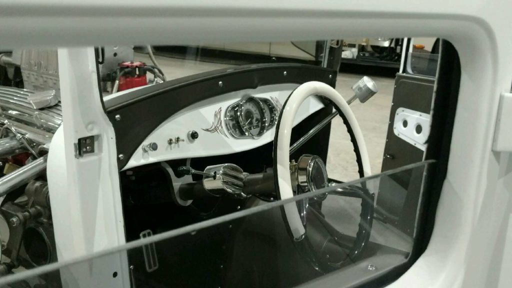 The interior of a white car with a steering wheel and steering wheel.