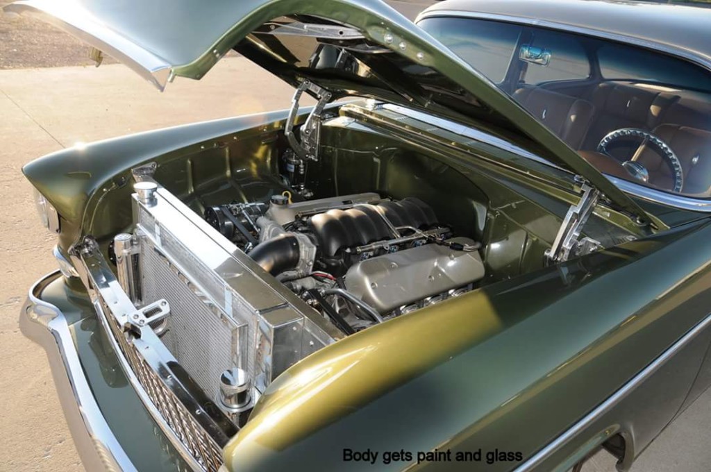 A green chevrolet bel air with the engine hood open.