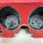 The dashboard of a red car with the DAKOTA DIGITAL HDX 3-1 GAUGES.