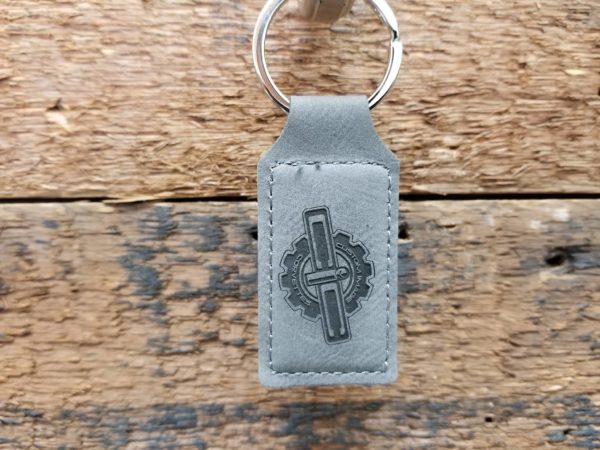 A grey leather Key Chain with a cross on it.