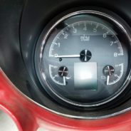 The dashboard of a red car with Dakota Digital HDX 3-1 Gauges.