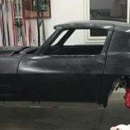 A black corvette sitting in a garage.