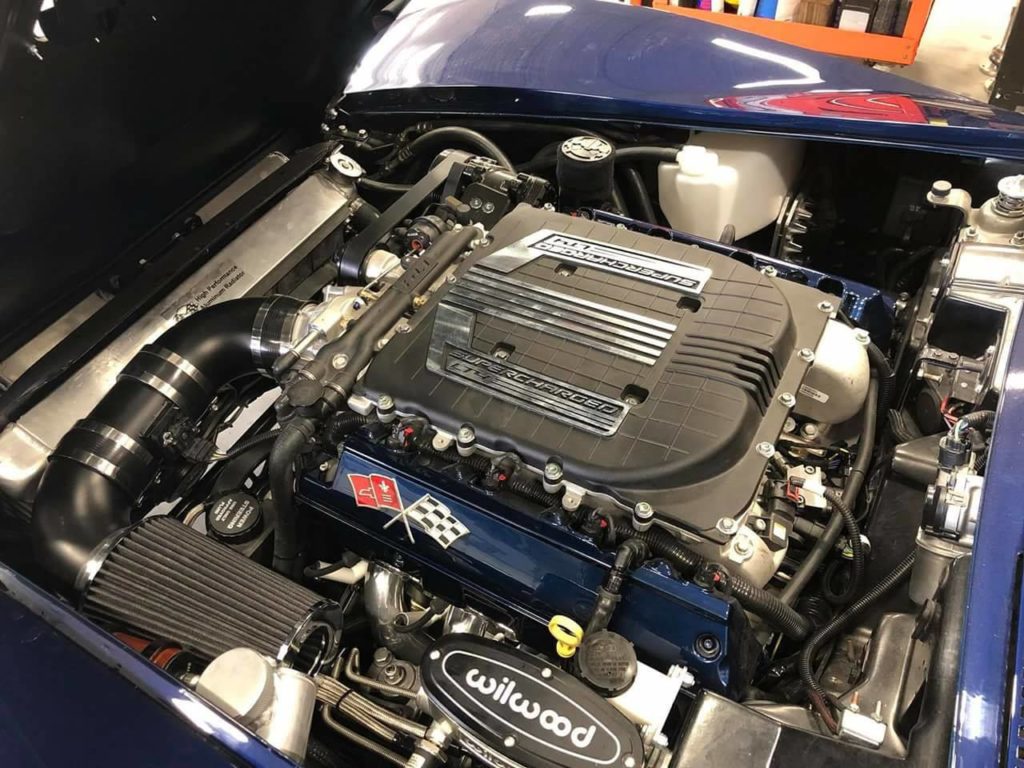 The engine compartment of a blue car.
