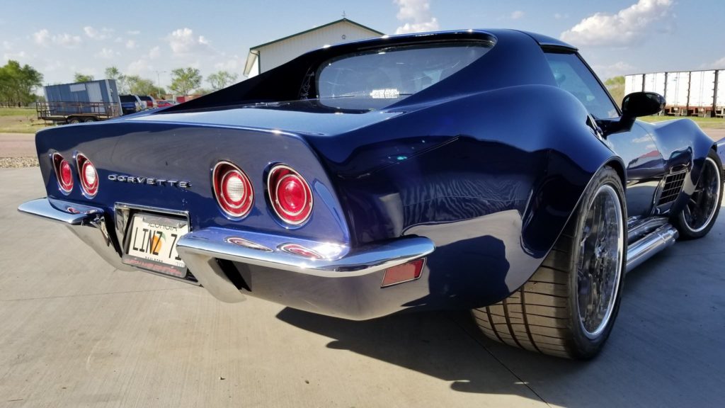A blue corvette parked in a parking lot.