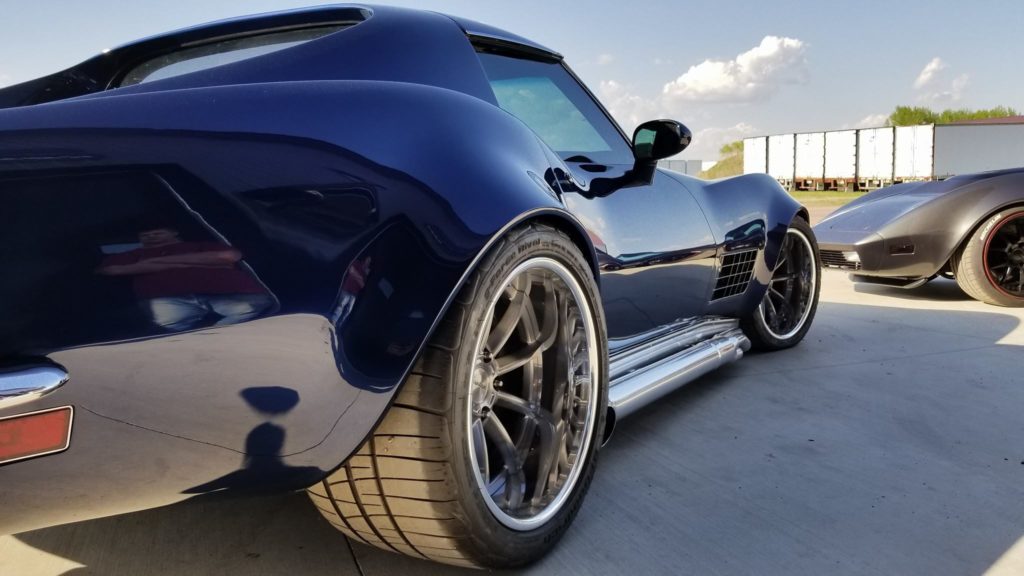 A blue chevrolet corvette parked in a parking lot.