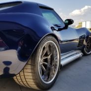 A blue chevrolet corvette parked in a parking lot.