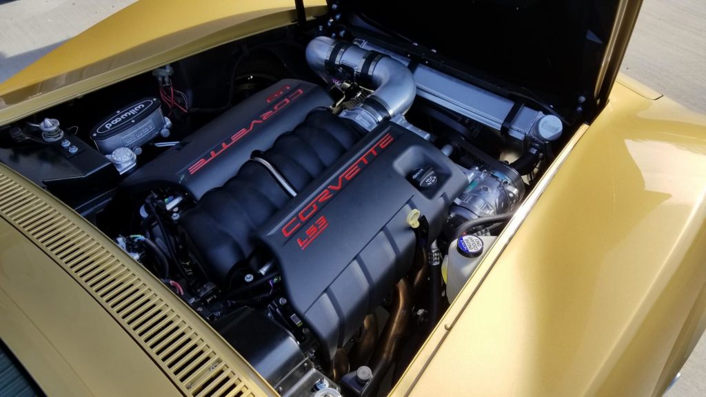 The engine compartment of a yellow sports car.