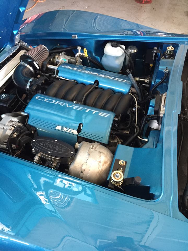 corvette with hood open and engine exposed in deep blue