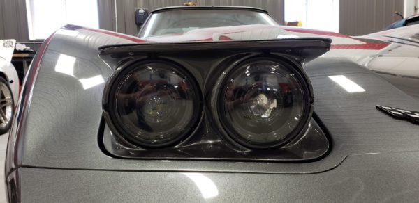 A close up of the Dapper Lighting 575 headlights of a silver sports car.