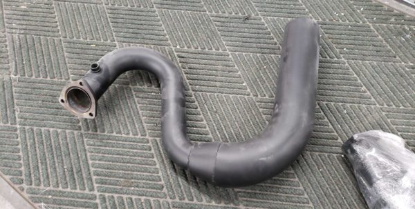 A C2 / C3 Side Exit Exhaust Smoothy Style Transition Pipes laying on the ground.