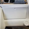 A white C3 CORVETTE CUSTOM DASH (Speedvette styled) with a door handle on it.