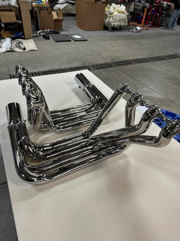 C2/C3 Corvette LS Swap Stainless Steel Side Exit Headers - polished finish on a white table in a warehouse setting.