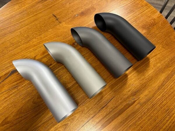 A group of C2/C3 CORVETTE LS SWAP STAINLESS STEEL SIDE EXIT HEADERS - CERAMIC FINISH on a table.