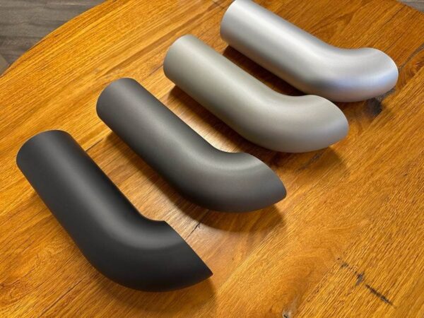 A set of C2/C3 CORVETTE LS SWAP STAINLESS STEEL SIDE EXIT HEADERS - CERAMIC FINISH pipe fittings on a wooden table.