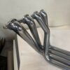 A pair of C2/C3 CORVETTE LS SWAP STAINLESS STEEL SIDE EXIT HEADERS - POLISHED FINISH on a table.