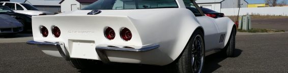 A white chevrolet corvette parked in a parking lot.