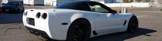 A white chevrolet corvette parked in a parking lot.